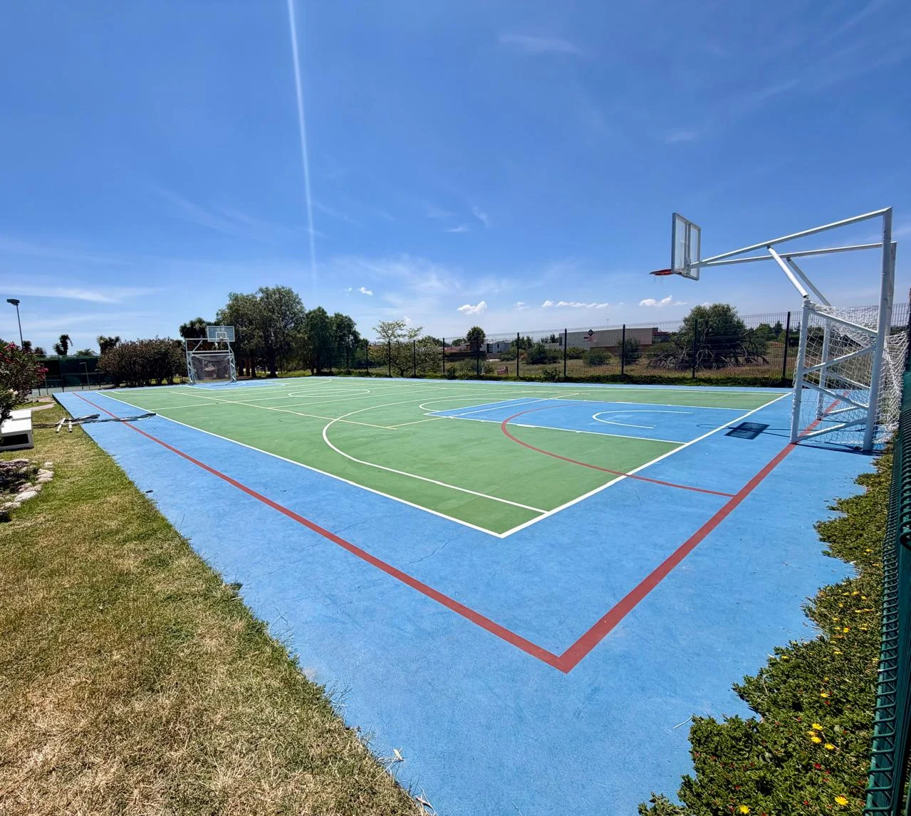 Cancha multiusos de Alquerías con canasta de básquetbol, portería y líneas deportivas.
