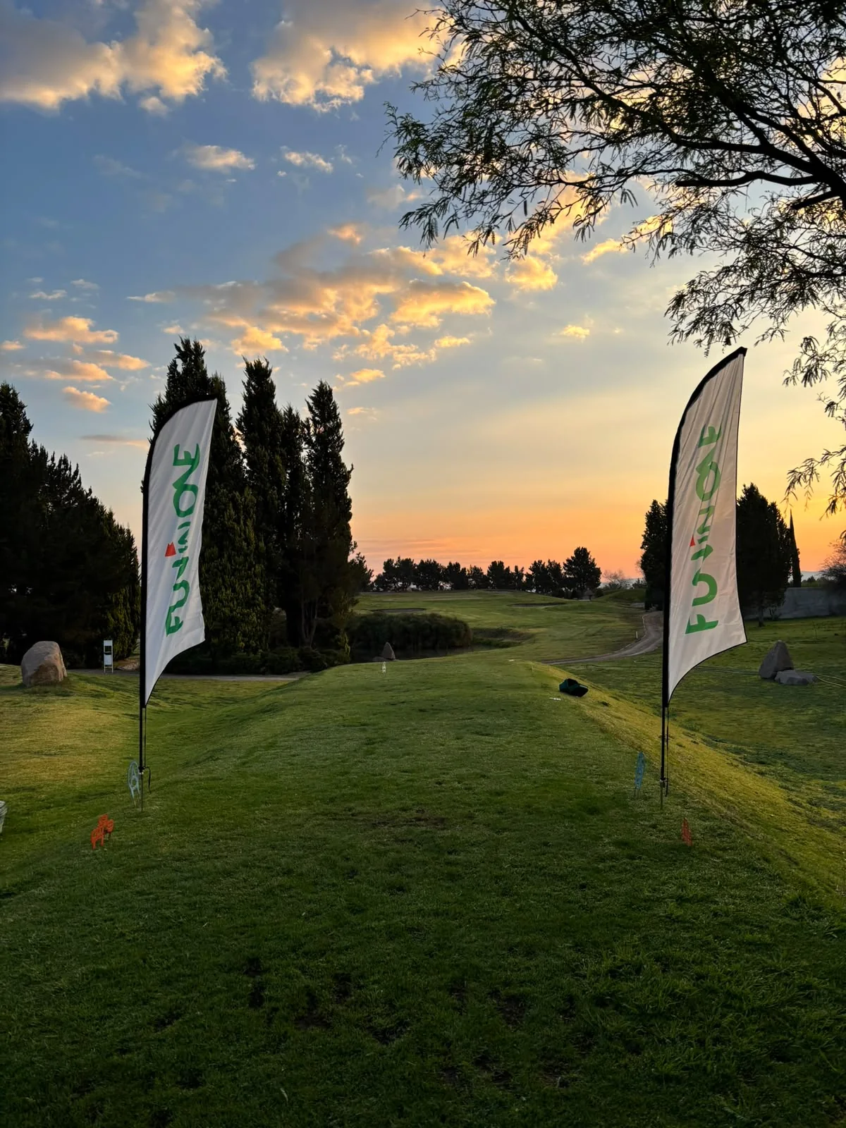 Salida del hoyo 7 de Alquerías con banderas de Fun In One al atardecer